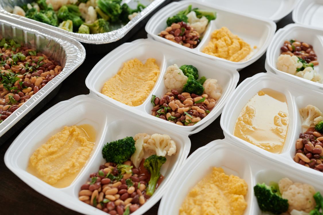 Meal prep containers with cooked chicken, rice, and vegetables stored in the fridge