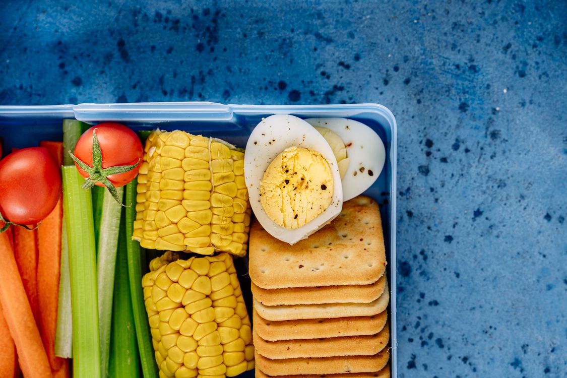 Hard-boiled eggs and healthy snacks arranged on a board