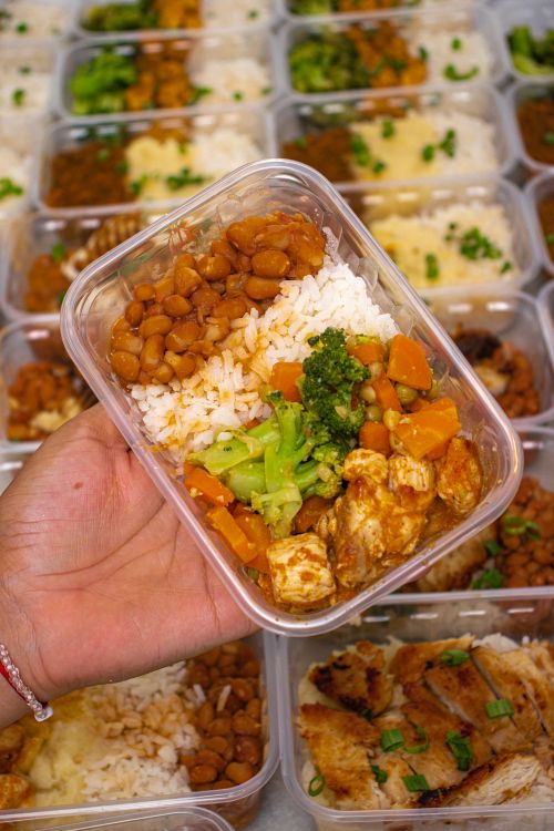 Colorful meal prep container with rice, chicken, beans, and vegetables
